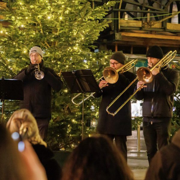 Eine kleine Blaskapelle bespielt die Besucherinnen und Besucher des Weihnachtsdorfes